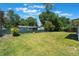 The backyard showcases lush greenery, mature trees and shrubbery and lush, healthy grass at 219 Stribling Dr, Auburndale, FL 33823