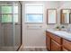 Bathroom featuring a vanity with marble countertop, a shower with a glass door, and natural light at 219 Stribling Dr, Auburndale, FL 33823