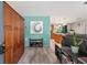 Spacious entryway featuring a large wood wardrobe, teal accent wall, and luxury vinyl plank flooring at 219 Stribling Dr, Auburndale, FL 33823