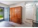 Entryway featuring beautiful floors, large wood wardrobe for storage and blue front door at 219 Stribling Dr, Auburndale, FL 33823