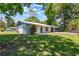 This charming single-story home features a metal roof, white siding, and a well-maintained green lawn at 219 Stribling Dr, Auburndale, FL 33823