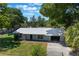 Charming single-story home featuring a silver metal roof, well-maintained lawn, and mature trees at 219 Stribling Dr, Auburndale, FL 33823