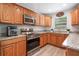 Modern kitchen with stainless steel appliances, granite countertops, oak cabinets, and ample counter space at 219 Stribling Dr, Auburndale, FL 33823
