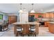 Bright kitchen with granite countertops, wood cabinets, stainless steel appliances, and a stylish island with bar stools at 219 Stribling Dr, Auburndale, FL 33823