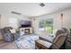 Cozy living room featuring a modern fireplace, chair, sofa, and large front window at 219 Stribling Dr, Auburndale, FL 33823