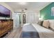 Spacious bedroom with a dresser, a TV, closets, light-colored wood floors, and light walls at 219 Stribling Dr, Auburndale, FL 33823