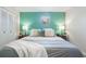 Comfortable main bedroom with green accent wall, lamps, wooden nightstands, and neutral bedding at 219 Stribling Dr, Auburndale, FL 33823