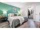 Bright main bedroom featuring a gray bed, lamps, wooden nightstands, and an open walk-in closet at 219 Stribling Dr, Auburndale, FL 33823