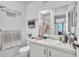 Bathroom with a large mirror above the vanity, and a shower over the toilet with glass doors in background at 2329 Oak Park Way # 204, Orlando, FL 32822
