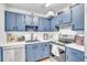Cozy kitchen with blue cabinets, white countertops, and stainless steel appliances offers both style and functionality at 2329 Oak Park Way # 204, Orlando, FL 32822