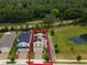 Aerial view of home with solar panels, green lawns, mature trees, and a scenic pond nearby at 2683 Bobcat Chase Blvd, Oakland, FL 34787