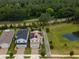 Aerial view of home with solar panels, green lawns, mature trees, and a scenic pond nearby at 2683 Bobcat Chase Blvd, Oakland, FL 34787
