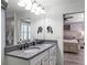 Elegant bathroom with double sinks, gray countertop, and access to the bedroom at 2683 Bobcat Chase Blvd, Oakland, FL 34787
