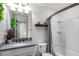 Well-lit bathroom features a gray countertop and a shower-tub combo with gray patterned curtain at 2683 Bobcat Chase Blvd, Oakland, FL 34787