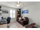 Bright bedroom features a ceiling fan, a large window, and a cozy leather loveseat at 2683 Bobcat Chase Blvd, Oakland, FL 34787