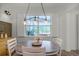 Cozy dining area featuring an round table, stylish lighting, and backyard views that create an inviting ambiance at 2683 Bobcat Chase Blvd, Oakland, FL 34787