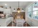 Charming dining area with a farmhouse-style table, white chairs, and a view into the modern kitchen at 2683 Bobcat Chase Blvd, Oakland, FL 34787