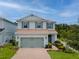 Charming two-story home featuring a brick driveway, two-car garage, and beautifully landscaped front yard at 2683 Bobcat Chase Blvd, Oakland, FL 34787