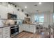 Well-designed kitchen with white cabinets, stainless steel appliances, and an adjacent dining area, perfect for modern living at 2683 Bobcat Chase Blvd, Oakland, FL 34787