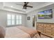 Comfortable main bedroom features a ceiling fan, TV, and an ensuite bathroom at 2683 Bobcat Chase Blvd, Oakland, FL 34787