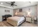 Bright main bedroom with a decorative brick accent wall, nightstands, and dark wood accent pieces at 2683 Bobcat Chase Blvd, Oakland, FL 34787
