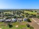 Aerial neighborhood view featuring well-maintained homes, golf course, sand trap, lake and mature trees at 2780 Highland View Cir, Clermont, FL 34711