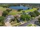 Aerial view of a beautiful home, golf course, and lake in a well-manicured community at 2780 Highland View Cir, Clermont, FL 34711