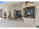 Relaxing covered patio featuring a ceiling fan, dining table, and view into the formal dining room through the glass pane window at 2780 Highland View Cir, Clermont, FL 34711