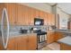 Close-up of kitchen showcasing stainless steel appliances, ample cabinetry, and mosaic backsplash at 2780 Highland View Cir, Clermont, FL 34711