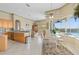 Open-concept living space features kitchen, dining area, and living room with tile floors and pool views at 2780 Highland View Cir, Clermont, FL 34711