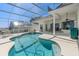 Beautiful in-ground pool and hot tub with screened-in enclosure, covered patio, and solar panels on the neighboring home at 2780 Highland View Cir, Clermont, FL 34711