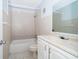 Bathroom featuring neutral-toned tile, tub, and a white single sink vanity at 3103 Yorych Ln, Orlando, FL 32822