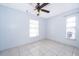 Bright bedroom with neutral walls, tile floors, two windows, and ceiling fan at 3103 Yorych Ln, Orlando, FL 32822