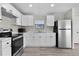 Modern kitchen with stainless steel appliances and white cabinets, ample counter space, and recessed lighting at 33506 Luana Ct, Leesburg, FL 34788