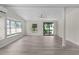 Inviting living room showcasing large windows, wood-look flooring, and a ceiling fan for a comfortable ambiance at 33506 Luana Ct, Leesburg, FL 34788