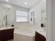 Bathroom featuring a bathtub, double vanity, and serene decor at 3420 Gerber Daisy Ln, Oviedo, FL 32766
