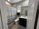 Modern bathroom with a sleek vanity, and bathtub with shower at 3420 Gerber Daisy Ln, Oviedo, FL 32766