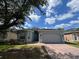 Charming single-story home featuring a brick-paved driveway, a two-car garage, and a blue front door at 3420 Gerber Daisy Ln, Oviedo, FL 32766