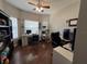 Well-lit home office featuring hardwood floors, two work stations, multiple monitors, and a cat tree at 3420 Gerber Daisy Ln, Oviedo, FL 32766