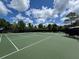 A well-maintained community tennis court, surrounded by lush trees and clear blue skies at 3420 Gerber Daisy Ln, Oviedo, FL 32766
