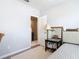 Comfortable bedroom with a view to the ensuite, a decorative mirror, and hardwood flooring at 3449 Seneca Club Loop # B, Orlando, FL 32808
