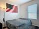 Simple bedroom with a queen bed, an American Flag, and natural light from the window at 3449 Seneca Club Loop # B, Orlando, FL 32808