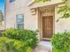 Charming front door with manicured bushes and flowering plants creating an inviting entrance to the home at 3449 Seneca Club Loop # B, Orlando, FL 32808