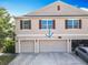 Two-story townhouse showcasing a multi-car garage, and neutral-colored exterior with well-placed windows and brown shutters at 3449 Seneca Club Loop # B, Orlando, FL 32808