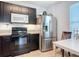 Bright kitchen featuring stainless steel appliances, including a refrigerator and oven at 3449 Seneca Club Loop # B, Orlando, FL 32808