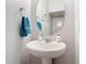 Classic powder room featuring a pedestal sink, round mirror, and decorative hand towel at 3449 Seneca Club Loop # B, Orlando, FL 32808