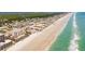 An aerial view of a beach, coastline, and community featuring condos and clear turquoise water at 4071 S Atlantic Ave # 803, New Smyrna Beach, FL 32169