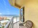 Relax in a chair on the condo's tiled balcony featuring ocean views and a sliding glass door to the interior at 4071 S Atlantic Ave # 803, New Smyrna Beach, FL 32169