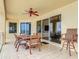 Open-air balcony featuring a dining table, ceiling fan, and access to the living room through sliding glass doors at 4071 S Atlantic Ave # 803, New Smyrna Beach, FL 32169