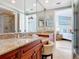 Bright bathroom featuring double sinks, granite countertops, and an open view into the bedroom at 4071 S Atlantic Ave # 803, New Smyrna Beach, FL 32169